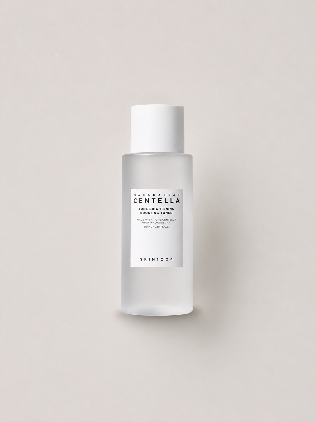 SKIN1004 Madagascar Centella Tone Brightening Boosting Toner 210 მლ — დაბურული მინის ბოთლში, ღია ბეჟ ფონზე